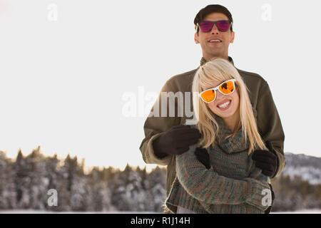 Couple de câliner portant des lunettes de soleil. Banque D'Images
