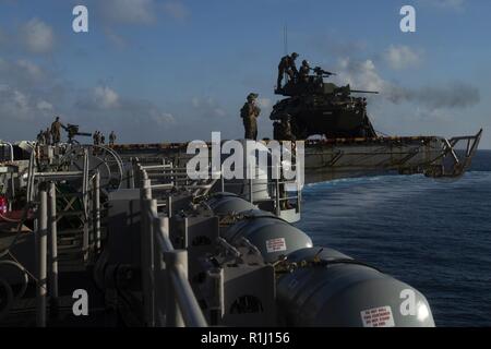 Marines avec des armes, de l'entreprise Équipe de débarquement du bataillon, 2e Bataillon, 5ème Marines, un incendie du véhicule blindé léger M242 Bushmaster 25 mm canon de la chaîne au cours de l'entraînement au tir d'avions à bord de l'élévateur de portside navire d'assaut amphibie USS Wasp LHD (1), en cours dans le sud de la mer de Chine, le 24 septembre 2018. Au cours de la formation, les Marines ont organisé les slaves au sommet de l'envol du Wasp pour affiner leurs capacités de tir d'agir en tant que la sécurité du navire. La 31e MEU, le Marine Corps' seulement continuellement de l'avant-déployés MEU, fournit une force flexible prêt à réaliser une vaste gamme d'opérations militaires. Banque D'Images