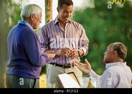 Smiling group of friends parler à un rassemblement social. Banque D'Images