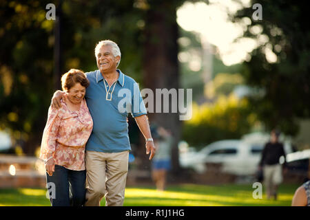 Smiling mature couple en train de marcher dans un parc. Banque D'Images