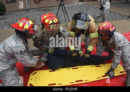 Les pompiers avec le 51e Escadron de génie civil l'incendie et d'urgence préparer une simulation de vol victime d'être traités par le personnel médical au cours d'un exercice à grand nombre de blessés à Osan Air Base, République de Corée, le 20 septembre, 2018. Le service d'incendie a travaillé en étroite collaboration avec le 51e Groupe médical pour évaluer leur temps de réponse et la formation sur l'évacuation des blessés à partir d'un angle élevé, pour les transporter sur les soins médicaux, et recevant un traitement. Banque D'Images