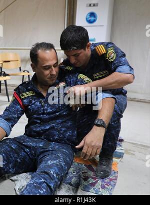 Les membres de la Police fédérale irakienne effectuer des techniques de soins sur le terrain pendant la formation au camp de Dublin, l'Iraq, le 24 septembre, 2018. Depuis janvier 2015 le personnel de la Coalition ont assuré la formation de plus de 150 000 soldats irakiens et les femmes de tous les rangs, y compris 55 000 membres de l'armée iraquienne ; près de 25 000 et 72 000 policiers autour de la sécurité, des gardes frontière et de contre-terrorisme personnel. Banque D'Images