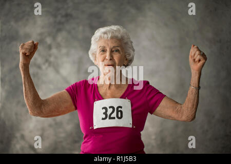 Portrait of a happy senior femme exhibant ses muscles du bras. Banque D'Images