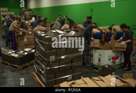 Les Marines et les marins charger les boîtes avec les pommes à la banque alimentaire de San Francisco San Francisco pendant la Semaine de la flotte, le 4 octobre 2018. Au total, le service chargé des membres 23 000 livres de pommes sur des palettes qui seront expédiées le jour-même à plus de 400 offices dans la région de San Francisco. Le San Francisco Banque alimentaire rss 144 000 personnes chaque semaine et offre 49 millions de livres de nourriture chaque année. La coopération et la coordination des relations établies au cours de la semaine de San Francisco, favoriser le développement et le partage des meilleures pratiques dans l'aide humanitaire et est reconnu par l'Organisation des Stat Banque D'Images