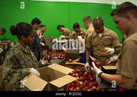 Les Marines et les marins charger les boîtes avec les pommes à la banque alimentaire de San Francisco San Francisco pendant la Semaine de la flotte, le 4 octobre 2018. Au total, le service chargé des membres 23 000 livres de pommes sur des palettes qui seront expédiées le jour-même à plus de 400 offices dans la région de San Francisco. Le San Francisco Banque alimentaire rss 144 000 personnes chaque semaine et offre 49 millions de livres de nourriture chaque année. La coopération et la coordination des relations établies au cours de la semaine de San Francisco, favoriser le développement et le partage des meilleures pratiques dans l'aide humanitaire et est reconnu par l'Organisation des Stat Banque D'Images