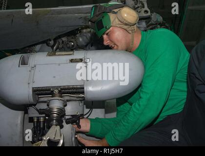 Océan Atlantique (oct. 4, 2018) l'Aviation aviateur mécanicien structurels James Clayton, de Wall Township, New Jersey et joint à l'Escadron d'hélicoptères de combat de la Mer 22, se desserre, un boulon sur un treuil de sauvetage sur un hélicoptère Seahawk MH-60S dans la zone de la classe Wasp-navire d'assaut amphibie USS Iwo Jima (DG 7). Iöjima ont récemment quitté son port d'attache de la station navale de Mayport suite à l'achèvement d'un service d'entretien continu de la disponibilité. Banque D'Images