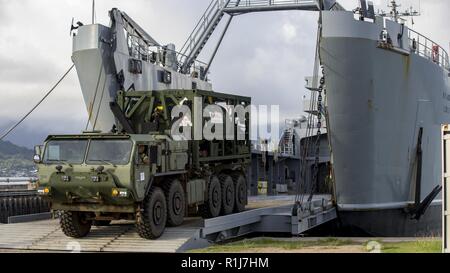 Avec les Marines américains du bataillon logistique de combat 3 (CLB-3) charger un camion de 7 tonnes sur un bateau de soutien logistique (LSV) à la marina sur base du Corps des Marines, La Baie de Kaneohe, Hawaii le 7 octobre 2018. L'engrenage et de l'équipement chargé sera transporté à la grande île d'Hawaï pour Bougainville Exercice II. Banque D'Images