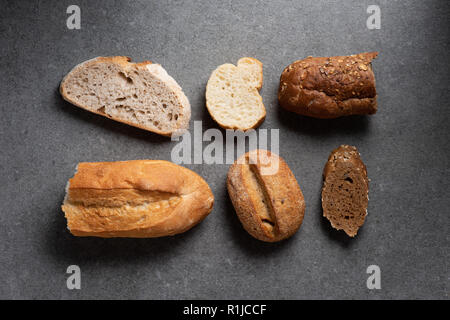 Mise à plat avec des morceaux de pain sur table gris divers Banque D'Images