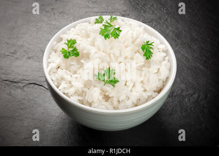 Une photo d'un bol de riz long blanc cuit sur un fond noir avec copie espace Banque D'Images