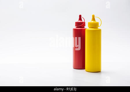 Close-up shot de bouteilles de ketchup et moutarde sur la surface blanche Banque D'Images