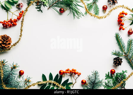 Mise à plat de fête avec la disposition des branches d'arbre de pin, l'argousier et décorations de Noël sur la table blanche Banque D'Images