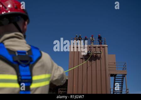 Les aviateurs de l'US Air Force assigné à la 633e Escadron de Génie Civil Transport Service d'incendie une victime au cours de l'évaluation finale à Joint Base Langley-Eustis, Virginie, 15 octobre 2018. Les pompiers ont participé à plusieurs exercices où ils ont construit des systèmes pour secourir les victimes simulées via la descente en rappel. Banque D'Images