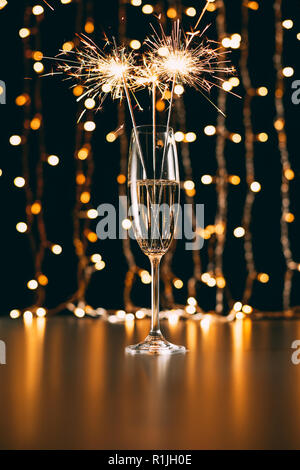 Champagne avec paillettes de Noël sur fond clair garland Banque D'Images