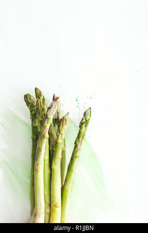 Vue de dessus du tas de tiges d'asperges sur surface blanche avec des traits d'aquarelle verte Banque D'Images