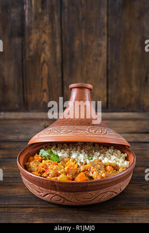 Tajine, couscous plats traditionnels et salade fraîche sur table en bois rustique. Tagine d'agneau et de potiron. Banque D'Images