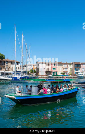 Bateau de tourisme dans la lagune Port Griamud ville, Var, Provence-Alpes-Côte d'Azur, France, Europe Banque D'Images