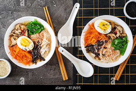 Végétarien régime bol de soupe de nouilles de champignons shiitake, carottes et œufs durs. La nourriture japonaise. Vue d'en haut. Mise à plat Banque D'Images
