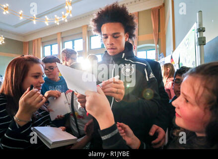 13 novembre 2018, Saxe, Leipzig : Soccer : Allemagne, conférence de presse de l'équipe nationale avant le match international contre la Russie (15.11.) dans le Sportoberschule Leipzig. Dvd Leroy Sané (M) donne des autographes aux élèves après une série de questions. Photo : Jan Woitas/dpa-Zentralbild/dpa Banque D'Images