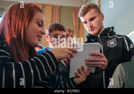 13 novembre 2018, Saxe, Leipzig : Soccer : Allemagne, conférence de presse de l'équipe nationale avant le match international contre la Russie (15.11.) dans le Sportoberschule Leipzig. Dvd Timo Werner (r) donne des autographes aux élèves après une série de questions. Photo : Jan Woitas/dpa-Zentralbild/dpa Banque D'Images