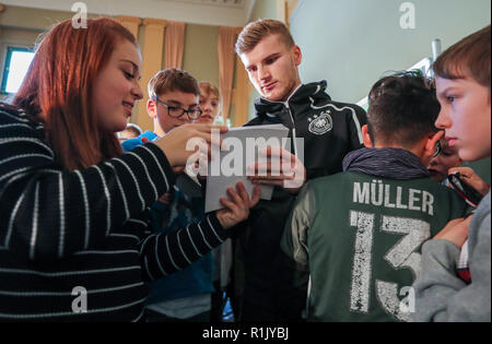 13 novembre 2018, Saxe, Leipzig : Soccer : Allemagne, conférence de presse de l'équipe nationale avant le match international contre la Russie (15.11.) dans le Sportoberschule Leipzig. Dvd Timo Werner (2e à partir de la droite) donne des autographes aux élèves après une série de questions. Photo : Jan Woitas/dpa-Zentralbild/dpa Banque D'Images