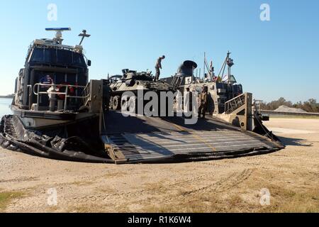 Un véhicule blindé léger de la Marine américaine sur la rampe de chargement des disques durs d'un Landing Craft Air Cushion au Mile Hammock Bay, Camp Lejeune, Caroline du Nord, 5 octobre 2018, au cours d'entraînement amphibie Commandant Type. Ptemp permet à la 24e unité expéditionnaire de marines, leurs unités subordonnées, et la marine américaine d'Iwo Jima du groupe amphibie de répéter la manœuvre du navire à la terre et de la force expéditionnaire et de contrôle avant l'exercice Trident stade 2018. L'objectif de PTEMP est d'accroître la compétence individuelle et de l'unité pendant les opérations amphibies. La LAVs sont avec 2e Bataillon de reconnaissance blindé, 24 Banque D'Images