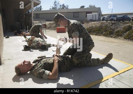 Lance le Cpl. Ryan Pirozzoli, agent de la police militaire avec le grand prévôt's Office (PMO), du Marine Corps Base Camp Pendleton (MCB), une simulation de bandages enroulés sur la FPC. Tristan Wilhelm, agent de la police militaire avec BGP, MCB Camp Pendleton pendant un cours de premiers soins et réanimation cardio-classe à MCB Camp Pendleton, en Californie, le 9 octobre 2018. Les Marines participant à la classe ont appris des techniques d'économie de la vie, qui comprenait une manœuvre de Heimlich, bandages et de démonstration de l'application de l'éclisse du membre et les fonctions d'un défibrillateur externe automatique. Banque D'Images