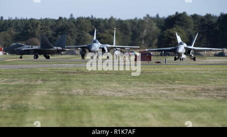 Un F-15C Eagle affecté à la 493rd Fighter Squadron, un F-22 Raptor affecté à la 1ère Escadre de chasse, Joint Base Langley-Eustis, en Virginie et un F/A-18F Super Hornet affectés à l 'Red Rippers' de Strike Fighter Squadron (VFA-11), déployé à partir de la classe Nimitz porte-avions USS Harry S. Truman (CVN 75) se préparer à lancer pour une sortie le 9 octobre 2018, à la Royal Air Force Lakenheath, Angleterre. Les Raptors sont la formation avec des pays alliés et partenaires comme une démonstration de l'engagement des États-Unis à la sécurité régionale. Banque D'Images