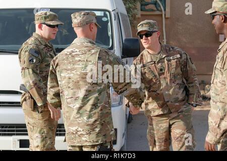 Le Lieutenant-colonel de l'US Air Force Paul Andrews, 16e Escadron d'opérations spéciales de la Force expéditionnaire du commandant, le Lieutenant-colonel de l'armée américaine salue Jessie Griffith, commandant du 925e Bataillon du contractant, au cours de sa bataille circulation à Al Asad Air Base (AAAB), l'Iraq, 5 octobre 2018. AAAB est une combinaison d'un groupe de travail conjoint - Fonctionnement amélioré la capacité inhérente de résoudre partenaire emplacement consacre à la formation des forces des partenaires et renforcer leur efficacité. Banque D'Images