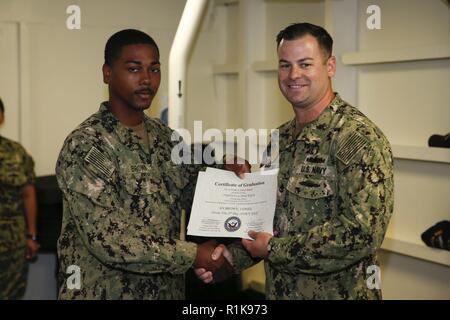 NEWPORT NEWS, Virginie (oct. 5, 2018), l'Aviateur de Loniel Brown de Chicago, affectés à l'USS Gerald R. Ford (CVN 78) Ministère de l'air, les forces de sécurité de la Marine reçoit son certificat de sentinelle de l'obtention du diplôme de Master Chef d'armes Gregory Brooks, affectés à la sécurité du ministère, Ford au cours de la Force de réaction de Sécurité Classe de base l'obtention du diplôme. Banque D'Images