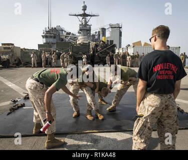 La mer d'OMAN - Marines des États-Unis avec la 13e Marine Expeditionary Unit (MEU), participer à un cours de la confiance de l'oléorésine de capsicine à bord de la classe Whidbey Island landing ship dock USS Rushmore (LSD 47), 10 octobre 2018. Le groupe amphibie d'Essex et la 13e MEU sont déployés dans le domaine de la 5e flotte américaine des opérations à l'appui des opérations navales pour assurer la stabilité et la sécurité maritime dans la région Centrale, reliant la Méditerranée et le Pacifique à travers l'ouest de l'Océan indien et trois points d'étranglement stratégiques. Banque D'Images