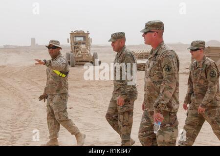 Le sergent de l'armée américaine. Armando Lopez, gauche, attribué à 387e compagnie du génie, 315e bataillon du génie, 301e Brigade, mémoires d'amélioration de Manœuvre un aperçu d'un projet d'agrandissement de l'aire d'attente des munitions à Al Asad Air Base (AAAB), l'Iraq, au Colonel Patrick Sullivan et commande le Sgt. Le major John Brennan, le commandant et le sergent major, respectivement, de 20e Brigade du génie, au cours de leur circulation de bataille le 10 octobre 2018. AAAB est une combinaison d'un groupe de travail conjoint - Fonctionnement amélioré la capacité inhérente de résoudre partenaire emplacement consacre à la formation des forces des partenaires et renforcer leur efficacité. Banque D'Images