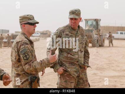 Le capitaine de l'armée américaine Andrew Eshelman, gauche, commandant de la 387ème compagnie du génie, 315e bataillon du génie, 301e Brigade, d'amélioration de Manœuvre répond aux questions sur un projet d'agrandissement de l'aire d'attente des munitions au Colonel Patrick Sullivan, commandant de la 20e Brigade, ingénieur au cours de sa bataille circulation à Al Asad Air Base (AAAB), l'Iraq, le 10 octobre 2018. AAAB est une combinaison d'un groupe de travail conjoint - Fonctionnement amélioré la capacité inhérente de résoudre partenaire emplacement consacre à la formation des forces des partenaires et renforcer leur efficacité. Banque D'Images