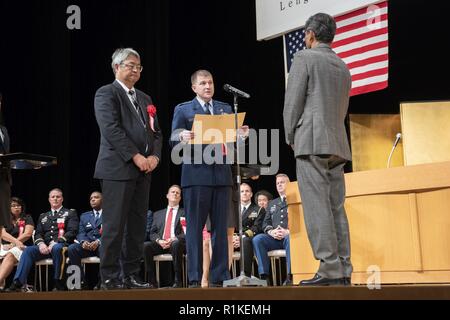 Koutarou Yoshida, directeur du Bureau de la défense de Kanto Nord général, à gauche, et le Colonel Dominique A., Kiefe 5e chef d'état-major de l'Armée de l'air, à droite, présente le prix de 30 années de service à Suzuki Hiraku, 374e Escadron de génie civil contremaître peintre-B, au cours de l'USFJ Durée de service Cérémonie de remise des prix de la Yutorogi Hamura Hall à City, Japon, le 10 octobre 2018. L'événement a été l'occasion pour l'USFJ et le Gouvernement du Japon pour célébrer le service national des employés qui ont contribué à 10, 20, 30 et 40 ans pour la poursuite du succès et de la croissance du partenariat entre l'U.S Banque D'Images