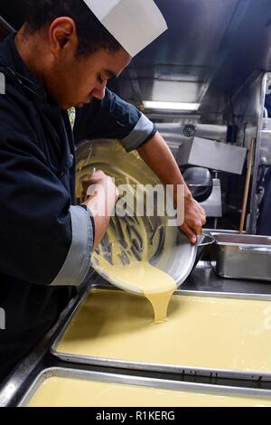 Mer Méditerranée (oct. 14, 2018) - Spécialiste culinaire Seaman Hunter ThomasMoore verse la pâte à gâteau à bord de la classe Arleigh Burke destroyer lance-missiles USS Ross (DDG 71) dans la mer Méditerranée, le 14 octobre 2018. Ross, l'avant-déployé à Rota, en Espagne, est sur sa septième patrouille dans la sixième flotte américaine zone d'opérations à l'appui de la sécurité nationale des États-Unis d'Europe et d'Afrique. Banque D'Images