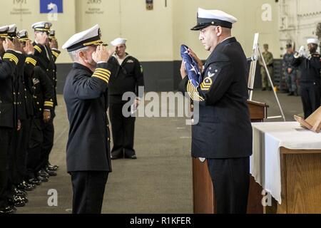 NORFOLK, Virginie (oct. 15, 2018) Le capitaine Sean R. Bailey, commandant du porte-avions USS George H. W. Bush, salue l'enseigne tenue par la commande Master Chief Jorge Soto pendant un service commémoratif. L'équipage du navire a organisé un service commémoratif en l'honneur Aviation maître de Manœuvre (manipulation), apprenti aviateur Joseph Naglak qui sont morts dans un accident d'envol, le 17 septembre 2018 tout en GHWB était en cours dans l'océan Atlantique. Banque D'Images