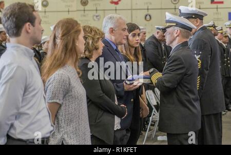 NORFOLK, Virginie (oct. 15, 2018) Le capitaine Sean R. Bailey, commandant du porte-avions USS George H. W. Bush (CVN 77), présente l'enseigne à la famille de l'aviation sur le maître de Manœuvre (manipulation), apprenti aviateur Joseph Naglak. L'équipage du navire a organisé un service commémoratif en l'honneur Naglak qui sont morts dans un accident d'envol, le 17 septembre 2018 tout en GHWB était en cours dans l'océan Atlantique. Banque D'Images