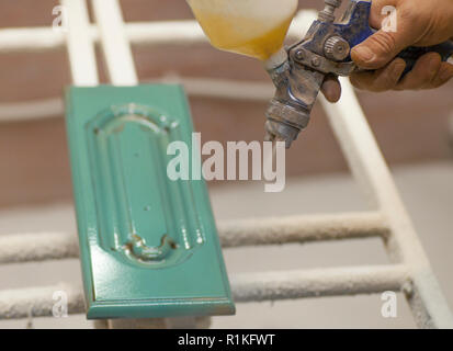 Les parties en bois de la peinture. Chambre de peinture, pistolet. La fabrication de meubles. Close-up Banque D'Images