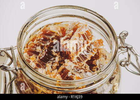Morceaux de miel dans un bol. Le miel d'abeilles frais en morceaux d'abeilles sur fond blanc. Banque D'Images