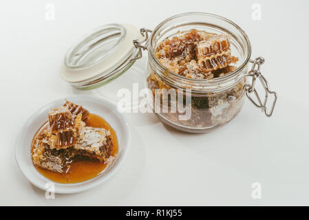 Morceaux de miel dans un bol. Le miel d'abeilles frais en morceaux d'abeilles sur fond blanc. Banque D'Images