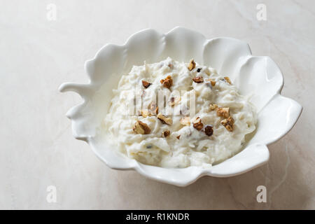 Salade de céleri avec du yaourt et des noix en forme de feuille d'exposition. L'alimentation biologique.