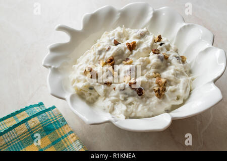Salade de céleri avec du yaourt et des noix en forme de feuille d'exposition. L'alimentation biologique.