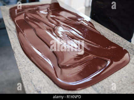 Chocolat mélange de travailleurs répartis sur une table d'usine Banque D'Images