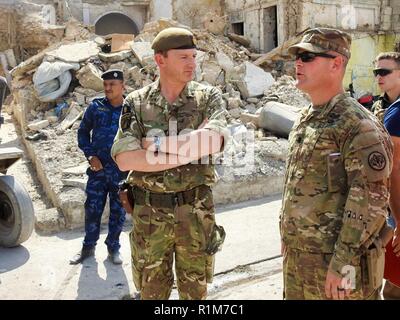 Le Lieutenant-colonel de l'armée américaine CJ Kirkpatrick, un commandant d'escadron au 3e régiment de cavalerie, le général britannique escortes Christopher Sophia, Combined Joint Task Force - Fonctionnement résoudre inhérent de commandant adjoint, dans les rues de Mossoul à observer la destruction causée par l'ISIS, 9 octobre 2018. Le 3e régiment de cavalerie est déployée à l'appui de l'opération de travail, résoudre inhérent par, avec et par les forces de sécurité irakiennes et de la coalition pour vaincre ISIS dans les zones de l'Iraq et la Syrie. Banque D'Images