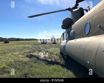 New York Army National Guard CH-47 Chinook de la société B, 3e bataillon du 126e, d'un délestage de l'Aviation 12 personne de l'équipe de recherche et de sauvetage et les véhicules tout-terrain à un endroit en Floride Wakulla Comté du 12 octobre suite à l'impact de l'ouragan Michael. La Garde Nationale de New York a déployé 11 équipes de personnel et deux aéronefs à l'appui de la Garde côtière en Floride 1er Bataillon, 111e Groupe de travail de l'Aviation. Crews a volé pendant trois jours, le transport, 32 240 livres de fret avant de retourner à leur vol à Rochester, N.Y. le 17 octobre. Banque D'Images