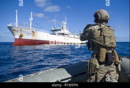 Un garde-côte américain avec détachement d'application de la loi de la Garde côtière canadienne 107, embarquée à bord de missiles de l'USS Shoup (DDG 86), prend une photo d'un bateau de pêche au cours de l'Europe Maritime Security Initiative (OMSI) programme dans l'ouest de l'océan Pacifique, le 21 octobre 2018. Le programme de l'OMSI est un ministre de la Défense Ministère de la Défense s'appuyant sur le programme d'actif en transit dans la région afin d'accroître la Garde côtière à la connaissance du domaine maritime, en fin de l'appui de ses opérations maritimes d'application de la loi de l'Océanie. Banque D'Images