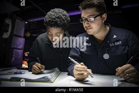 Mer Méditerranée (oct. 22, 2018) Spécialiste des opérations Seaman Zhana Brown, à gauche, de Newport, R.I., et spécialiste des opérations de 3e classe James Garcia, de Los Angeles, se regarder dans le centre d'information de combat à bord de la classe Arleigh Burke destroyer lance-missiles USS Carney (DDG 64) Le 22 octobre 2018. Carney, l'avant-déployé à Rota, en Espagne, est sur sa cinquième patrouille dans la sixième flotte américaine zone d'opérations à l'appui d'alliés et de partenaires régionaux ainsi que les intérêts de sécurité nationale des États-Unis en Europe et en Afrique. Banque D'Images