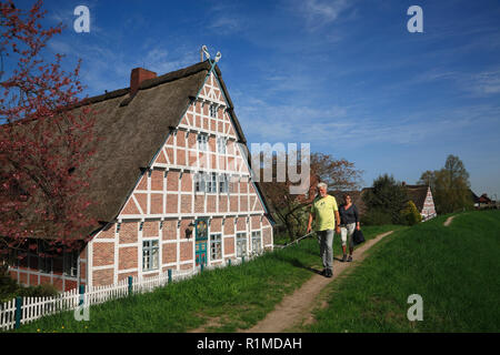 Randonneur en face d'une ancienne ferme à Este-Dyke, Jork-Koenigreich, Altes Land, Basse-Saxe, Allemagne, Europe Banque D'Images