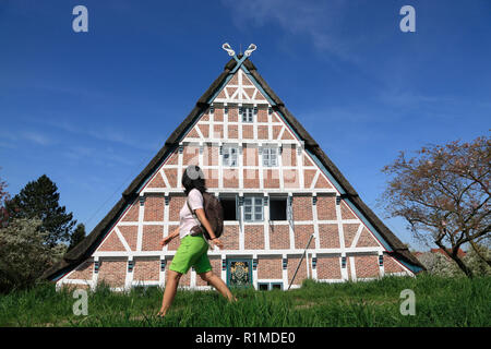 Randonneur en face d'une ancienne ferme à Este-Dyke, Jork-Koenigreich, Altes Land, Basse-Saxe, Allemagne, Europe Banque D'Images