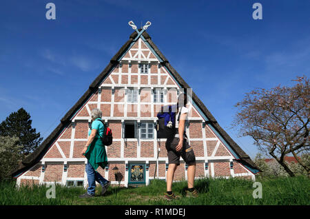 Randonneur en face d'une ancienne ferme à Este-Dyke, Jork-Koenigreich, Altes Land, Basse-Saxe, Allemagne, Europe Banque D'Images