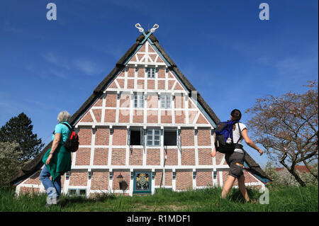 Randonneur en face d'une ancienne ferme à Este-Dyke, Jork-Koenigreich, Altes Land, Basse-Saxe, Allemagne, Europe Banque D'Images